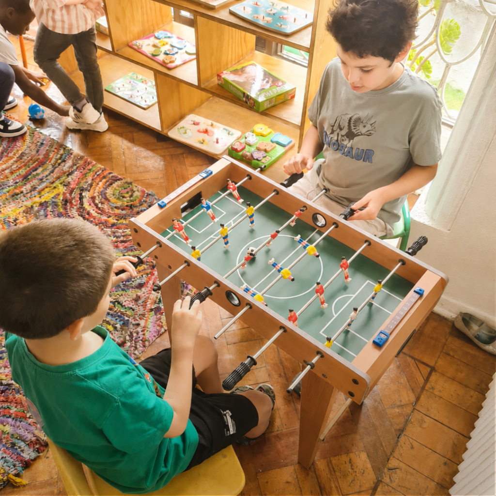 Niños jugando taca taca en el Afterschool de Casa Nidal